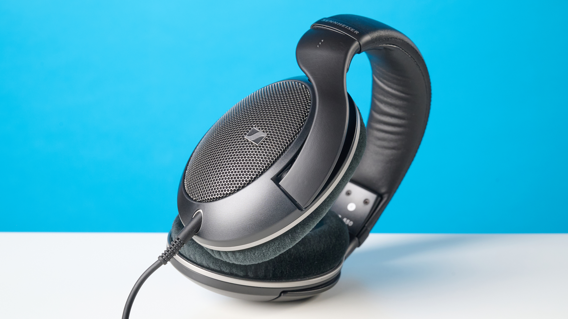 The Sennheiser HD 550 headphones on a stone surface with a blue background