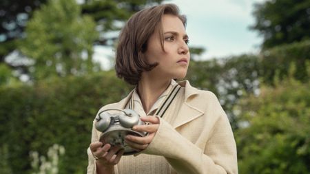 Lady Eileen holds a clock, facing away