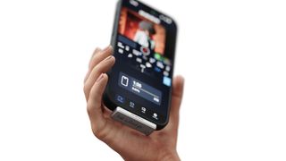 A person holding an iPhone with the ShiftCam PLANCK attached to it.