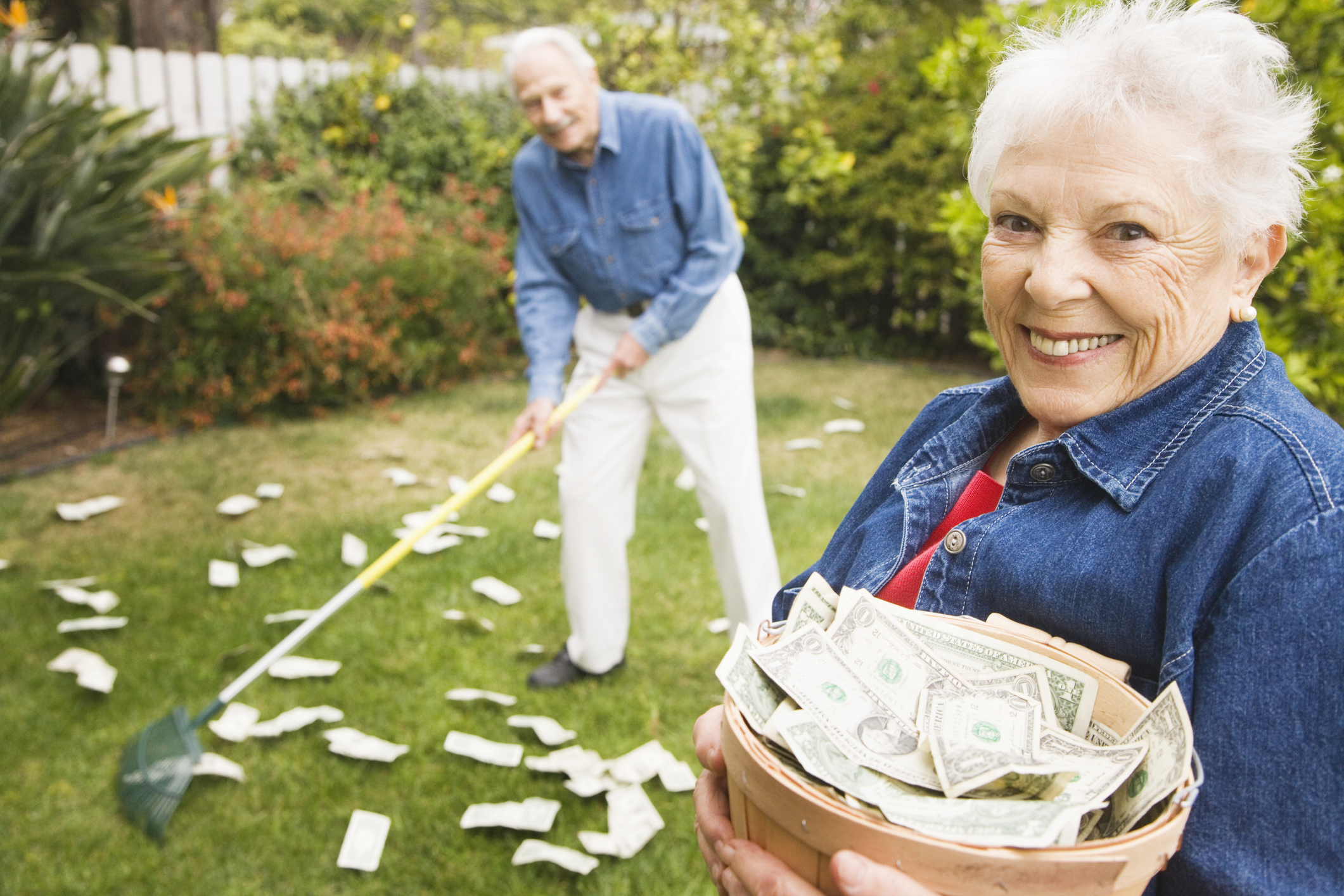 Senior Couple Raking Money in Yard