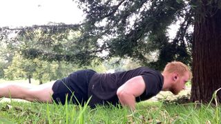 The author performs a push-up on grass