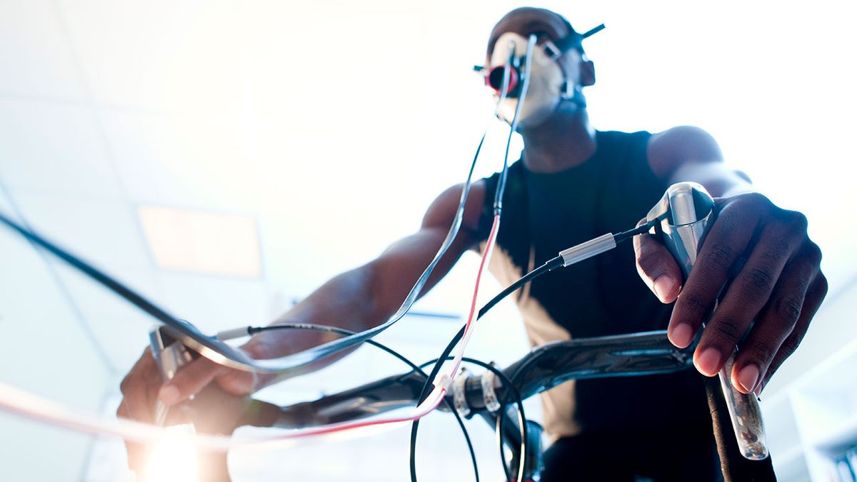 Athlete riding an exercise bike while his performance and oxygen consumption are measured