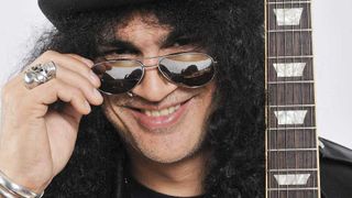 Slash in 2009, peering over the top of his sunglasses and grinning