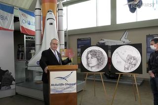 Steven McAuliffe (left), a U.S. District Court judge and widower of NASA's first "Teacher in Space," together with FIRST founder Dean Kamen unveil the art for the Christa McAuliffe Silver Dollar at the Shepard-McAuliffe Discovery Center in New Hampshire.