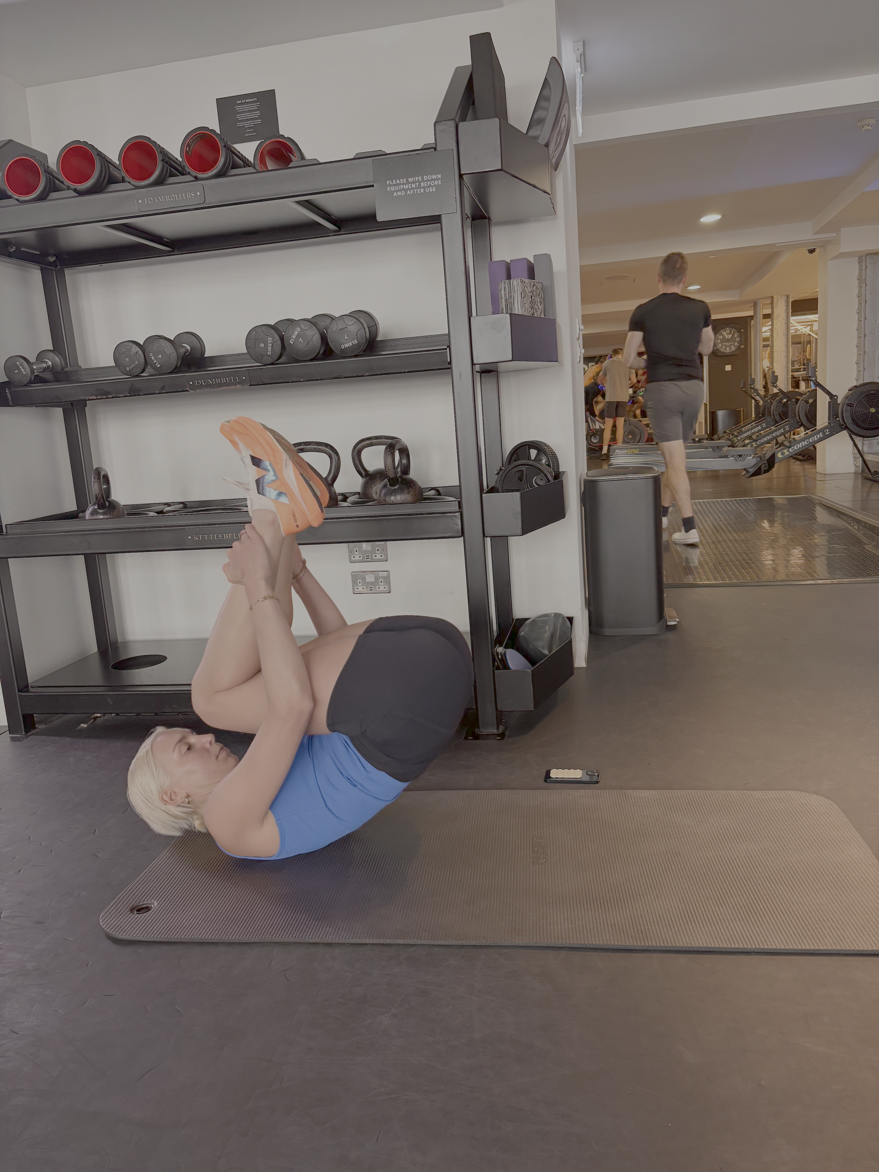 A woman practicing the Pilates rolling like a ball movement in a gym