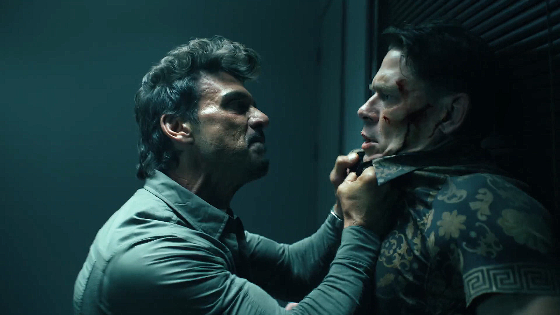 Rick Flag Sr looking angry and holding Chris Smith against a wall in Peacemaker season 2 episode 5