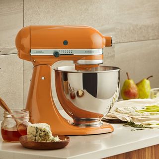 KitchenAid Artisan mixer in Orange on a kitchen counter surrounded by food