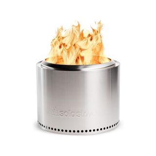 The stainless Solo Stove firepit with flames coming out of the top