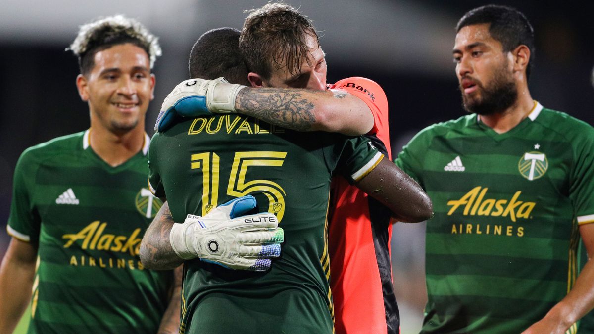 Portland Timbers goalkeeper Steve Clark and defender Chris Duvall embrace after defeating the Philadelphia Union in the MLS is Back tournament on August 5, 2020. The Timbers went on to win the tournament, and are near the top of the western conference.