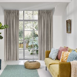living room with yellow sofa and curtains to garden