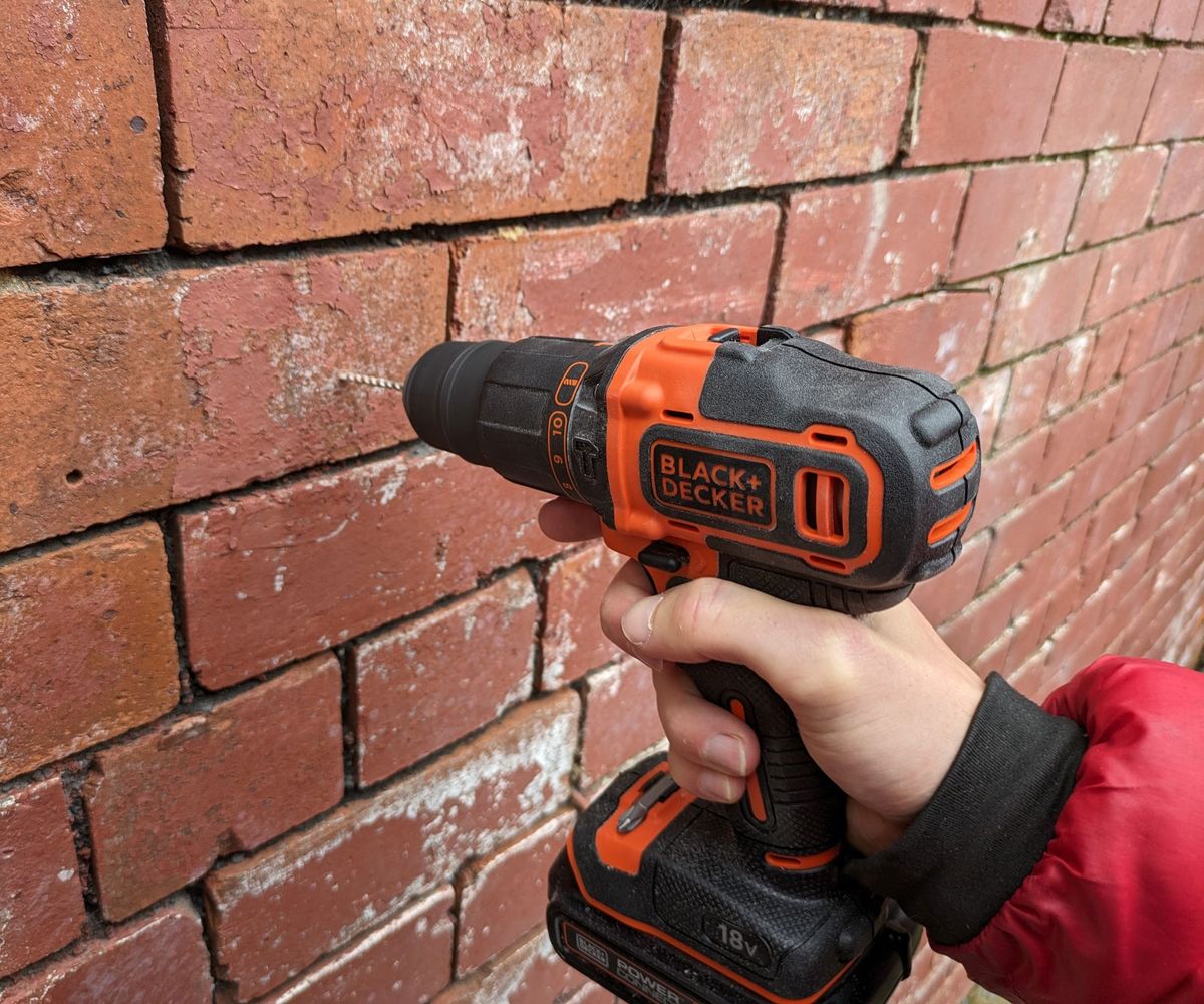 Black &amp; Decker combi drill drilling into brick