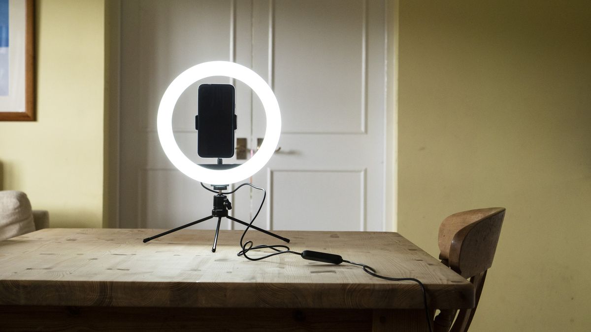 right light for phone switched on, placed on a wooden table with phone attached