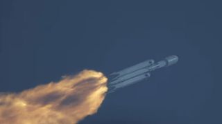 a sideways view of a falcon heavy rocket launching to orbit