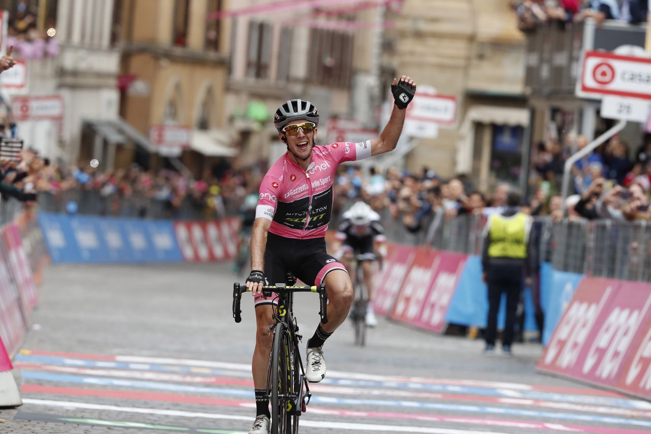 Simon Yates raises his arm in celebration