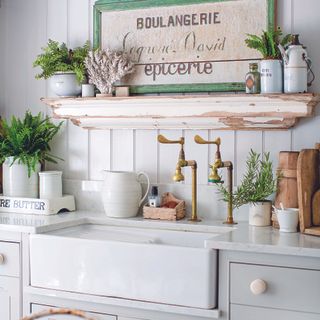 Rustic white kitchen with vintage handles and open shelving.