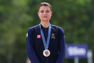 Bronze medallist Sweden's Jenny Rissveds celebrates on the podium after taking third place the women's cross-country mountain biking event during the Paris 2024 Olympic Games in Elancourt Hill venue in Elancourt, on July 28, 2024. (Photo by Emmanuel DUNAND / AFP)