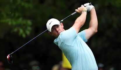 Rory McIlroy hits a drive whilst wearing a light blue polo shirt