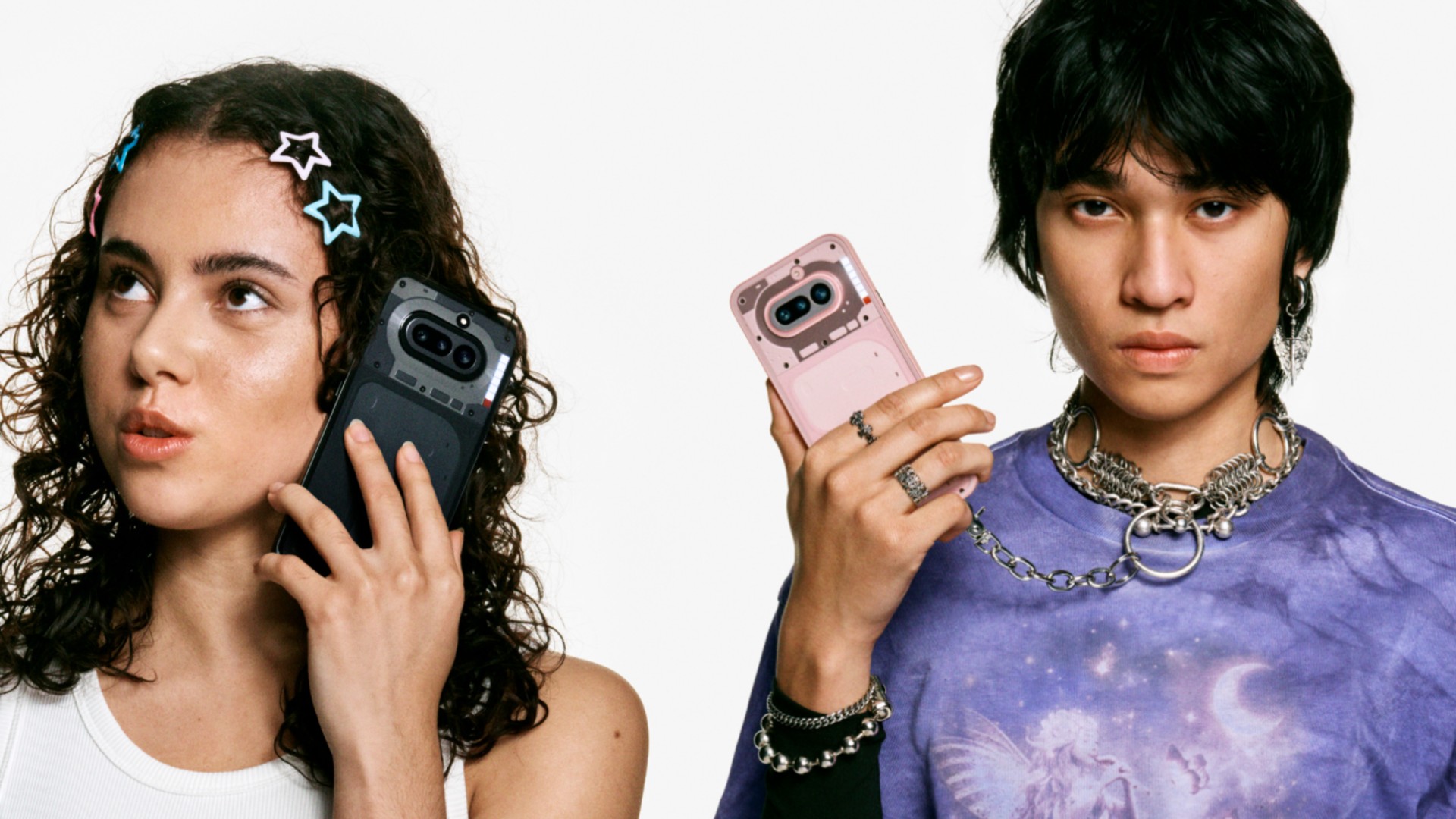Two young people pose against a white background while holding Nothing-branded smartphones that feature a signature transparent-style back design.