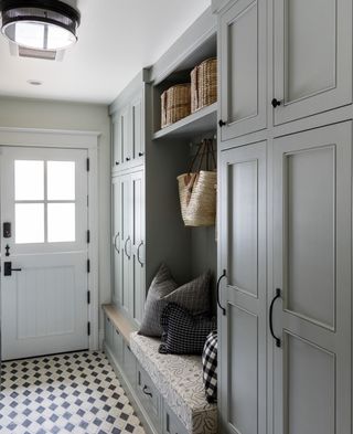 laundry room with gray storage, patterned flooring and bench