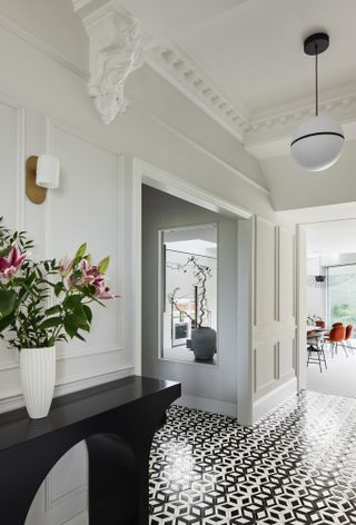 A cut out window in home with tile flooring and white wall panels across the room