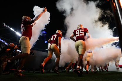 The Florida State Seminoles take the field to face the Louisville Cardinals during the ACC Championship 