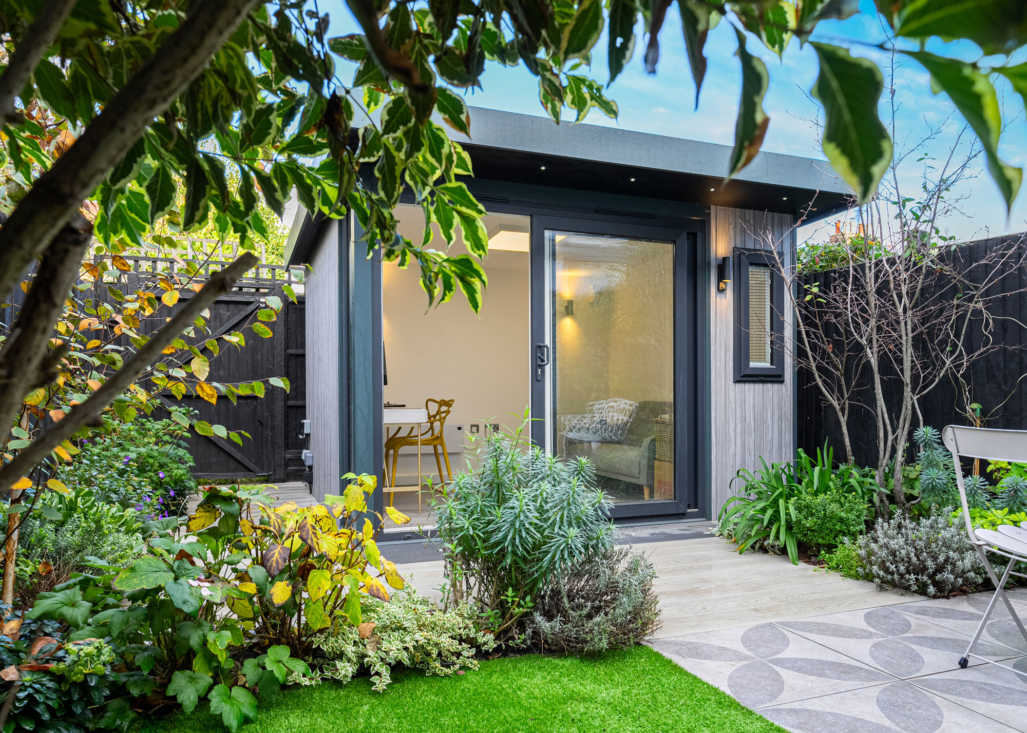 garden office with trees, planting, paving and lawn