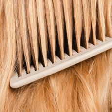 A comb running through blonde hair