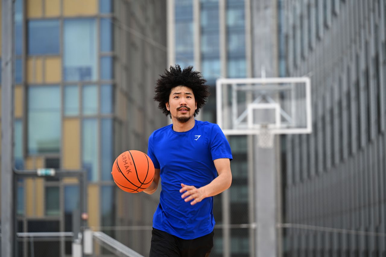 Person in playing basketball on a rooftop basketball court