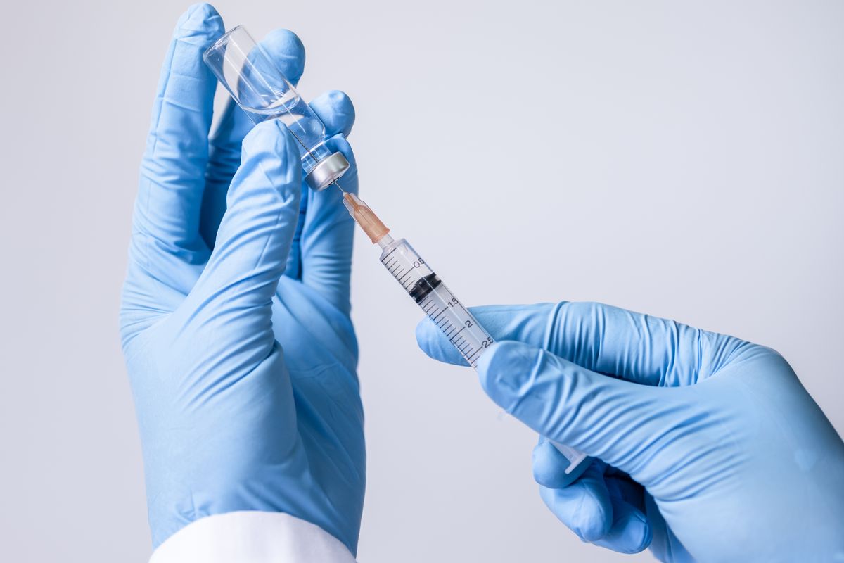 A healthcare professional holding a vaccine.