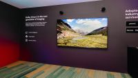 A large TV mounted on the wall of a CES showroom
