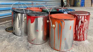 tins of paint stood on garage floor