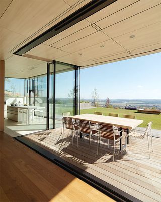 A first floor cantilever creates space beneath for an outdoor dining terrace connected to the house by corner glazing