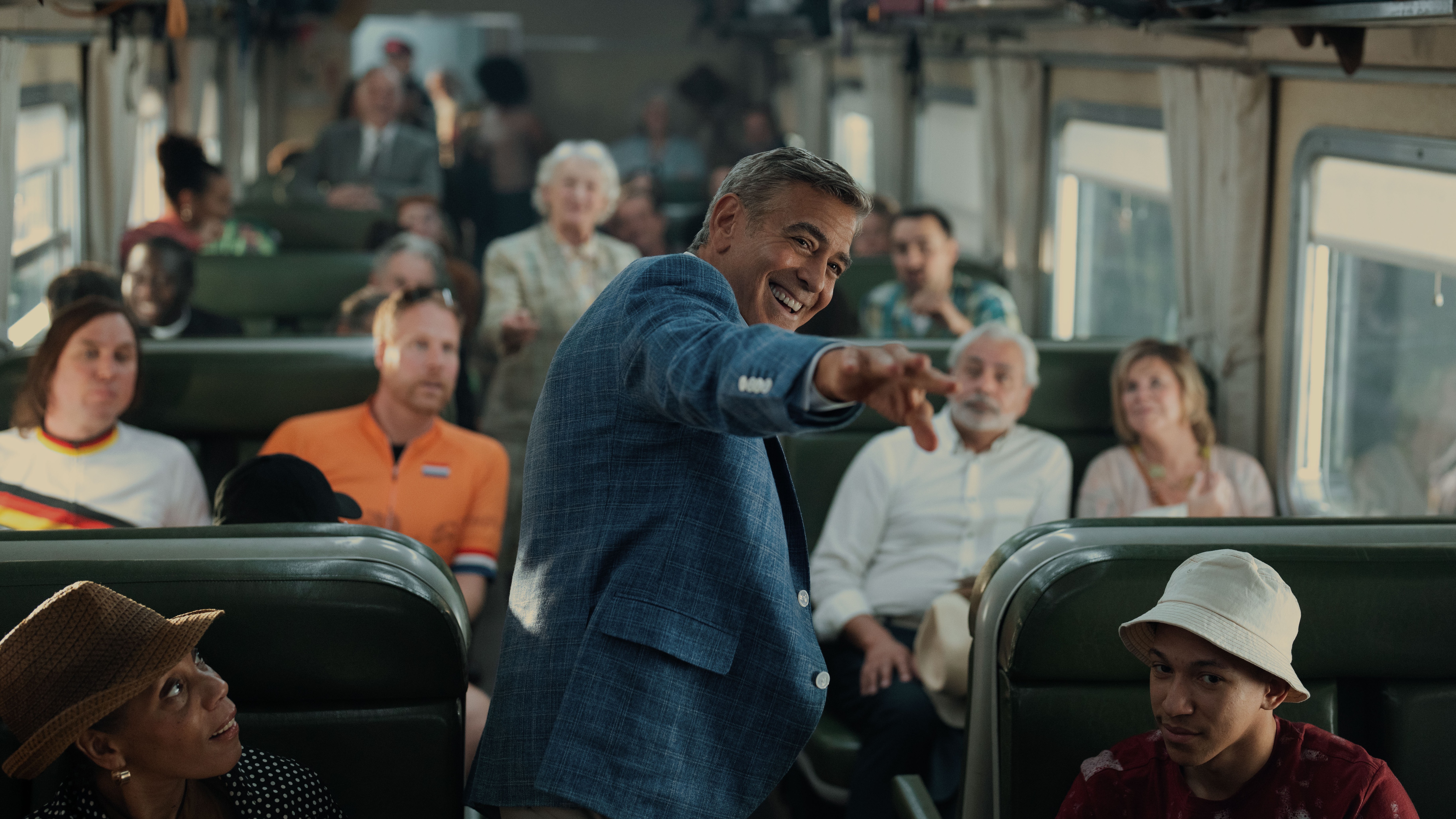 Jay Kelly (George Clooney) greets fans on a train in a scene from Netflix's "Jay Kelly"