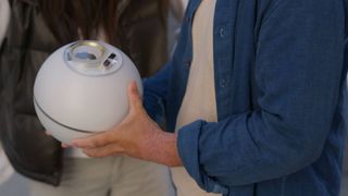 A World Orb iris eye scanner being held by someone
