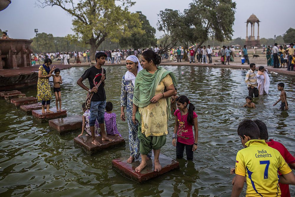 Families cool off in a pond during a heat wave on June 2, 2012, in New Delhi, India.