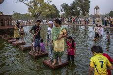 Families cool off in a pond during a heat wave on June 2, 2012, in New Delhi, India.