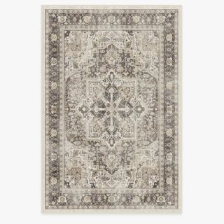 A large rectangular tufted rug with a washed out, neutral persian pattern