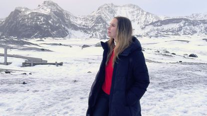 valeza wearing cold weather clothing from the article in front of a snowy mountain scene