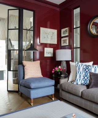 living room painted in a gloss red with modern black double doors leading onto the connecting room