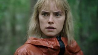 Daisy Ridley stands in the woods looking worried in Chaos Walking.