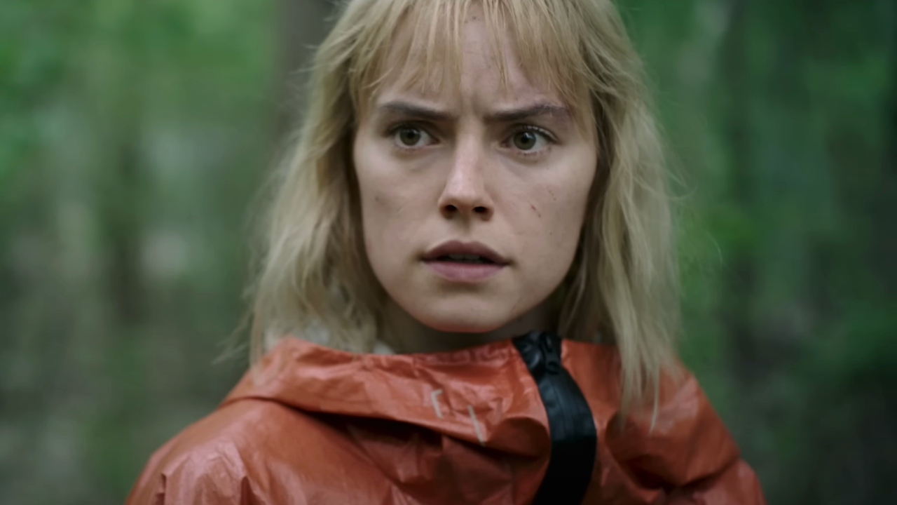 Daisy Ridley stands in the woods looking worried in Chaos Walking.