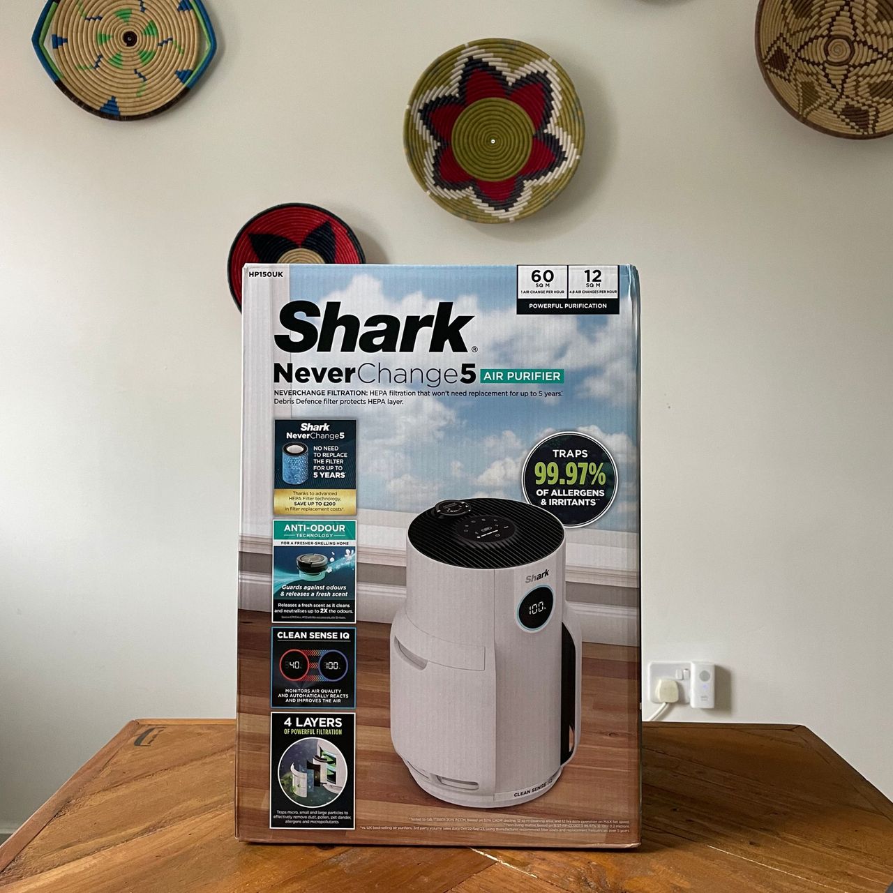 Shark NeverChange 5 Air Purifier box sitting on a wooden table in front of a white wall