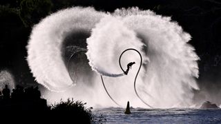 A water jet pack pilot spins around in the air on the Yarra River during the annual Moomba Festival in Melbourne