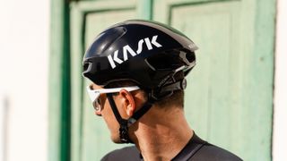 Kask Utopia Y helmet in black with white Kask logo being worn by a male cyclist 