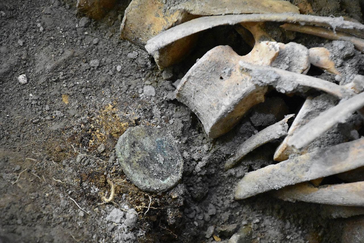 Gold coins and earrings found next to a skeleton