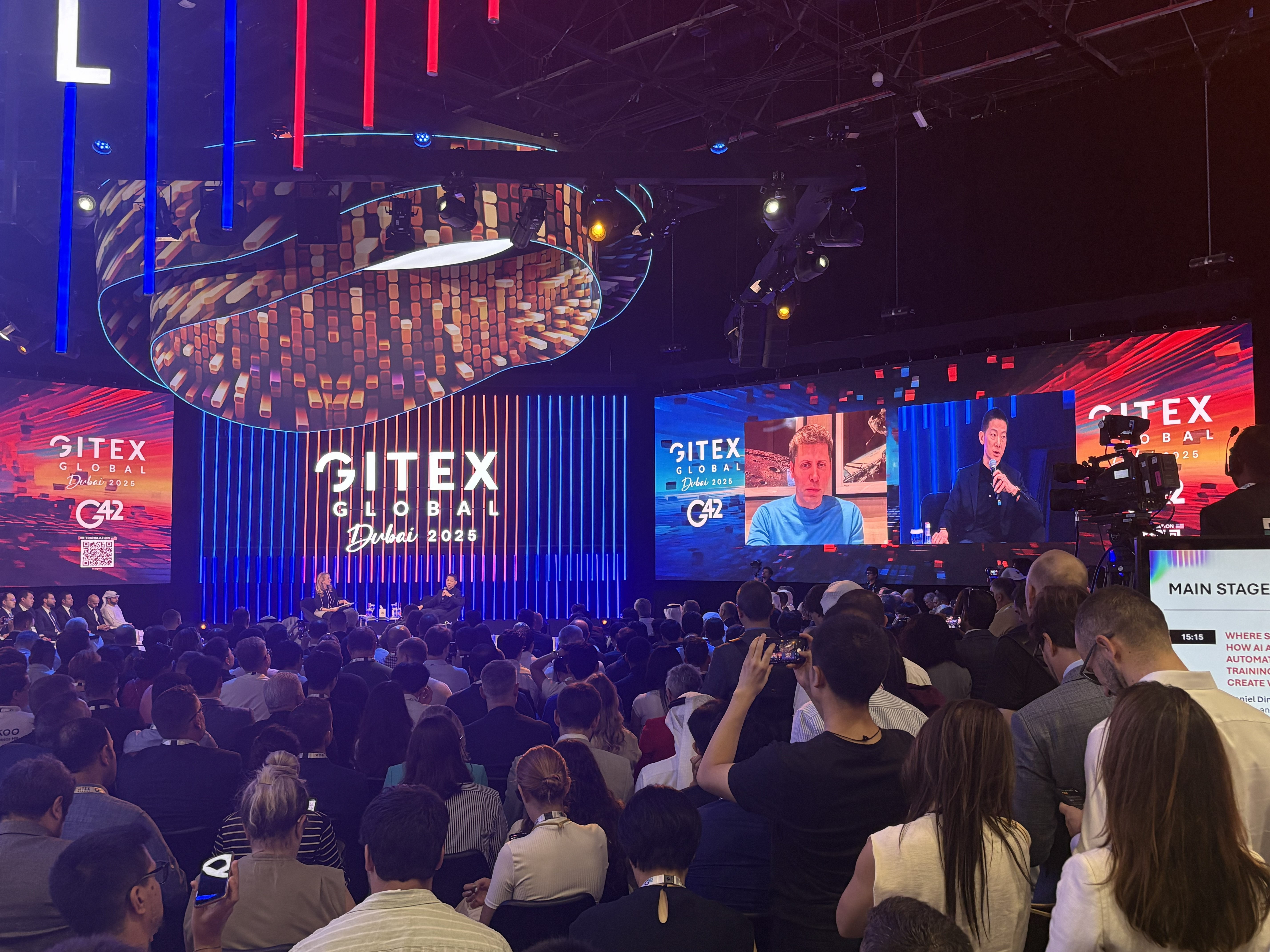 Image of Peng Xiao and Sam Altman performing on the GITEX main stage.
