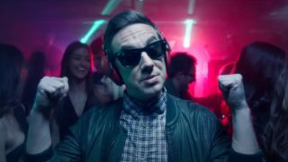Jorma Taccone wearing sunglasses and ear muffs in the YOLO music video.