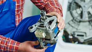 Repairman holding a washing machine motor