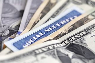 picture of a social security card in between U.S. currency
