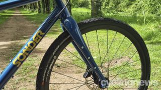 A close up of the triple fork mounts on a blue Sonder Camino gravel bike